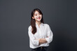 © Surachetsh - Asian woman is elegantly posing in a sleek white top and cloth against a pitch-black background, her captivating smile shining through. generative AI.