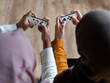 © Cultura Creative - High angle view of women using remote control playing video game