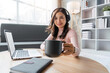 © Natee Meepian - Happy woman with resting, sitting on chair, watching webinar, working online on laptop, talking in video chat, drinking tea or coffee