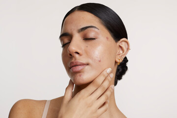 Wall Mural - Portrait of young woman with closed eyes against white background