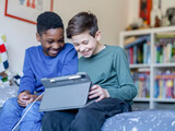 Fototapeta Londyn - Boy friends (8-9, 10-11) using digital tablet at home