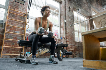 Canvas Print - Woman doing weight training with dumbbell on gym