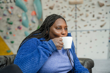 Canvas Print - Woman drinking coffee in front of climbing wall