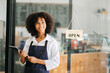 © Nuttapong punna - Startup successful small business owner sme African woman stand with tablet  in cafe restaurant. woman barista cafe owner. .