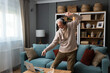 © Srdjan - Happy senior old grandfather man in wireless headphones dancing, singing at home, choosing favorite energetic disco music in mobile application, entertaining indoors. Retired people relax activities