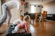 © Drobot Dean - Father rolling his children on pillows while having fun together at home