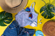 © ricka_kinamoto - Summer girl fashion flat lay on high-colored yellow background. Holiday party, vacation, travel comfortable casual woman outfit - t-shirt, shorts, flip flops, straw hat, sunglasses, with palm leaf