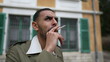 © Marco - One pensive serious young Middle Eastern man smoking a cigarette outside with thoughtful expression. Tracking shot closeup face in motion while brooding