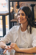 © Tatyana - Portrait of a happy young attractive dark-haired woman in a cafe.