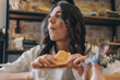 © Tatyana - Portrait of a young attractive dark-haired woman eating a sandwich in a cafe.