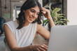© Tatyana - Attractive positive young woman using a laptop in a cafe.Remote work,blogging,business, freelance,e-learning.