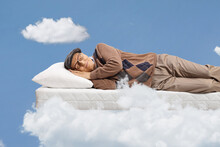 Elderly Man Sleeping On A Matress And Floating In A Sky
