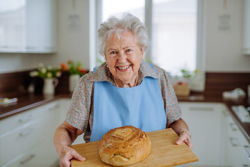 Portrait of senior woman with fresh baked bread.