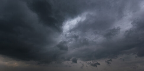 Wall Mural - The dark sky with heavy clouds converging and a violent storm before the rain.Bad or moody weather sky and environment. carbon dioxide emissions, greenhouse effect, global warming, climate change