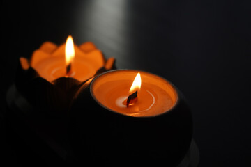 An aromatic candle burns in the dark and creates a romantic atmosphere. The fire is burning. A romantic candlelit dinner for two lovers. Romantic night of a man and a woman.