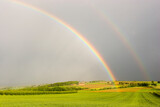 Fototapeta Tęcza - Half rainbow over a rural landscape with intensive colors