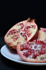 Wall Mural - Pomegranate fruit on a white plate. Delicious pomegranate fruit. Cut fruit.