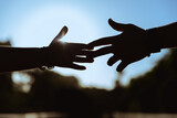 Fototapeta  - manos rozándose los dedos, a través de una increíble y magnifica puesta de sol, dando un adiós definitivo entre una pareja. 