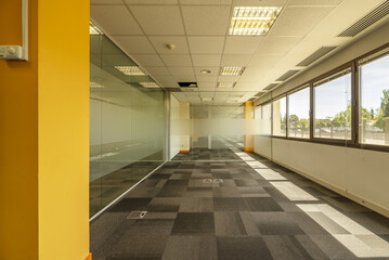 Wall Mural - Interior of an office building with open spaces divided with tempered glass partitions