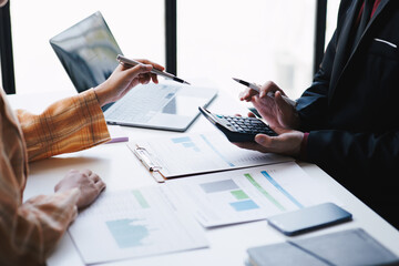 Close up view of business team analyzing accounting document with calculator in the office room together.