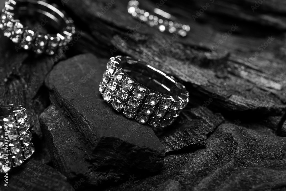 Silver rings on black charcoal, closeup