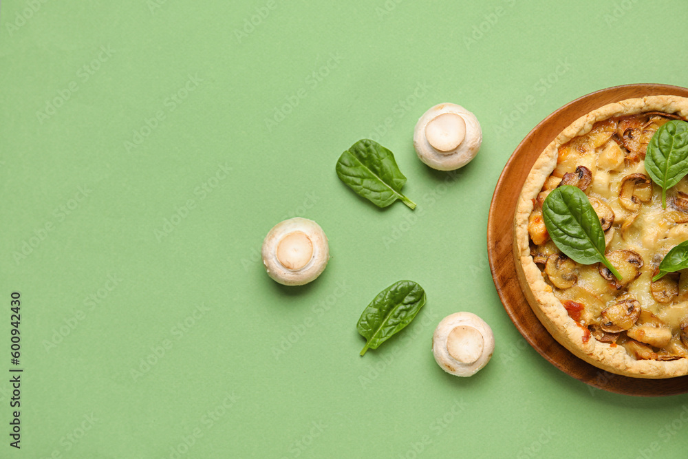 Mushroom pie with spinach leaves and champignons on green background
