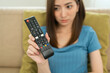 © Chanakon - Close up woman hand holding remote control pointing to change the programme television menu.