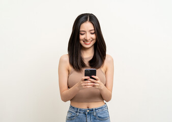 Pretty young asian woman using smartphone standing on isolated white background. Excited Beautiful young asian shopping online payment with mobile phone. Playing game on smartphone