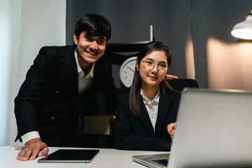 Couple two business man and woman working late at night. Discussion in office working with laptop. Boss and employee