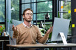© Liubomir - Businessman in a shirt resting and meditating in the office in the lotus position, a man at the workplace relaxes during the day sitting at the workplace with a laptop with his eyes closed.