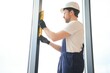 © Serhii - Worker using bubble level after plastic window installation indoors