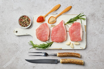 Wall Mural - Top view of uncooked pork cutlets on cutting board