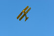 Beautiful yellow biplane airplane against the blue sky.