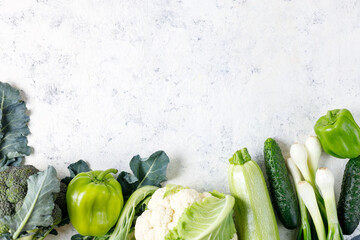 Wall Mural - Border of green raw vegetables on white background. Top view of healthy organic food. Copy space