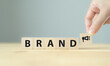 © Parradee - Brand advertising concept. Brand strategy for building consumer loyalty and increase customer base. Wooden cube blocks with BRAND text and advertising icon on clean background and copy space.