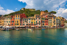 Multi Coloured Houses And Port Of Portofino, Luxury Tourist Resort In Genoa Province, Liguria, Italy, Europe. Waterfront And Promenade With Many Tourists On A Sunny Spring Day. Mediterranean Sea.