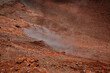 Vulkanlandschaft auf dem sizilianischen Ätna. Rotes Gestein mit Rauchwolken. Nutzbare Strukturen oder Texturen als Hintergründe für Webseiten.