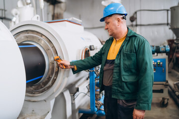 An engineer uses a thermal imager to check the heating temperature of a pvc pipe.