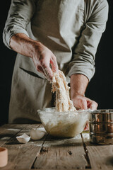 Wall Mural - Unrecognizable man in an apron kneading the dough