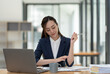© crizzystudio - Young Asian businesswoman holding a pen sitting and analyzing the details of management information Finance is happy at the desk in the office.