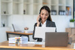 © crizzystudio - Confident smiling asian businesswoman analyzing charts and graphs showing changes in market and finance by holding a smartphone at the office,tax