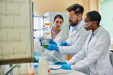 Wall Mural - multiracial group of scientist working with chemical liquids during research in laboratory.