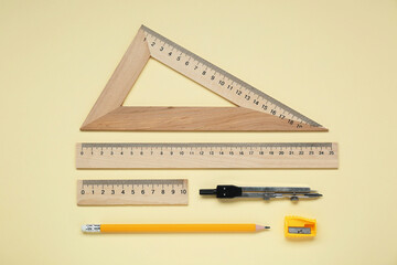 Wall Mural - Flat lay composition with different rulers and compass on yellow background