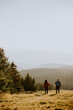 © BGStock72 - Smiling couple walking with backpacks over green hills