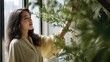 © Oliver - Young woman looking at a plant branch in window