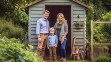 Portrait of happy family in front of a garden shed