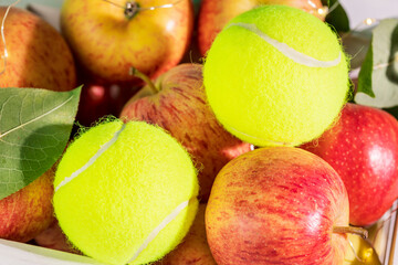 Wall Mural - Tennis composition with close up yellow tennis balls with natural red apples. Tennis competition. Concept of Healthy sport. Selective focus