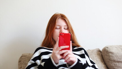 Teenager girl using mobile phone, chatting on web. Mobile app for smartphone. Children lifestyle concept. Kid showing blank screen mobile phone.