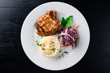 Sticker - Fried pork fillet steak with mashed potatoes and salad of fresh cabbage, carrots, onions.