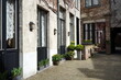 Hotel und Restaurant mit Innenhof im Sonnenschein mit buntem Blumenschmuck als Teil des Unesco Weltkulturerbe in der Heilige Geeststraat in der Altstadt von Brügge in Westflandern in Belgien